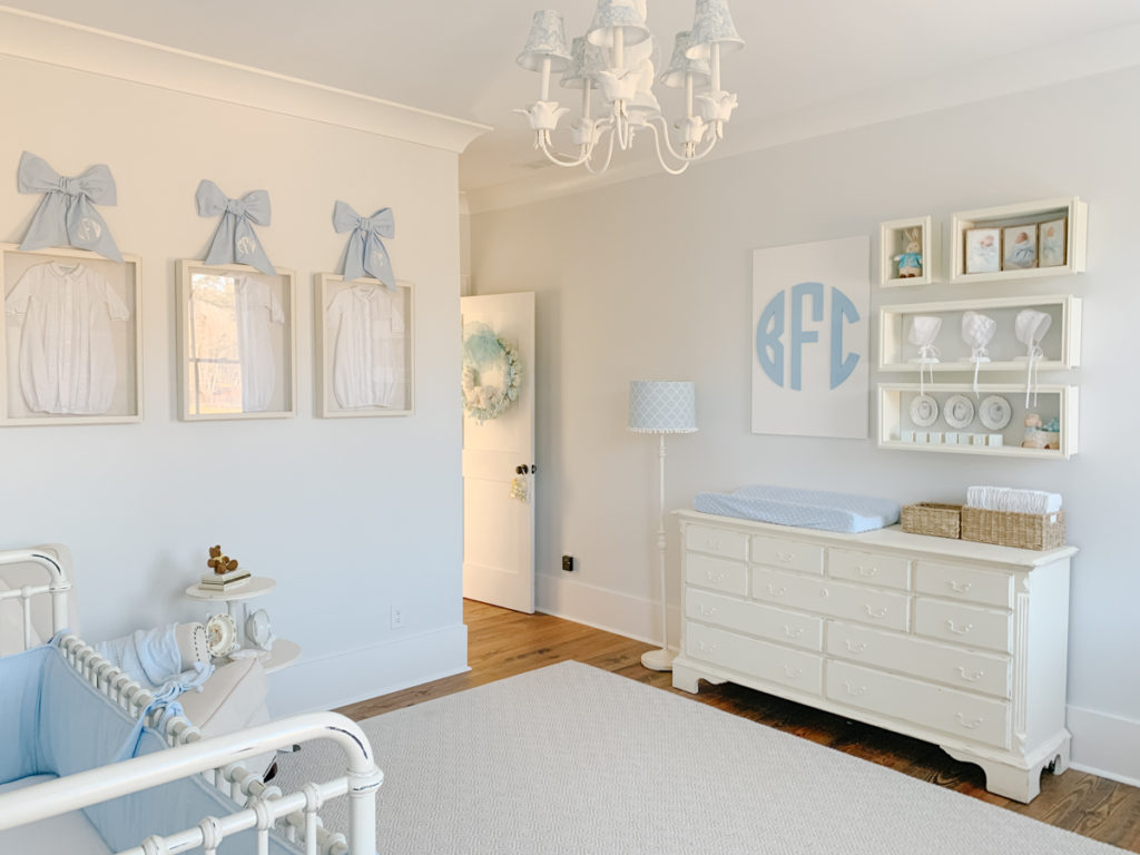custom wood monogram wall decor hanging on the wall above a dresser in a blue and white nursery 