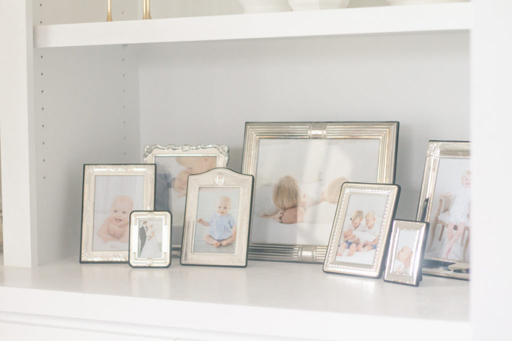 vintage thrift store godinger silver picture frames styled on a bookshelf filled with family photos