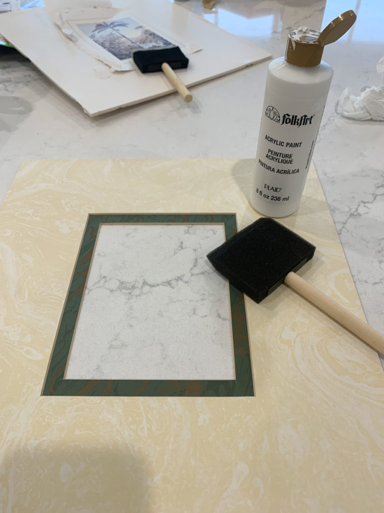 a picture mat with a bottle of craft paint and a foam paintbrush