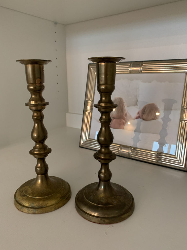 vintage brass candlesticks from a thrift store on a shelf 