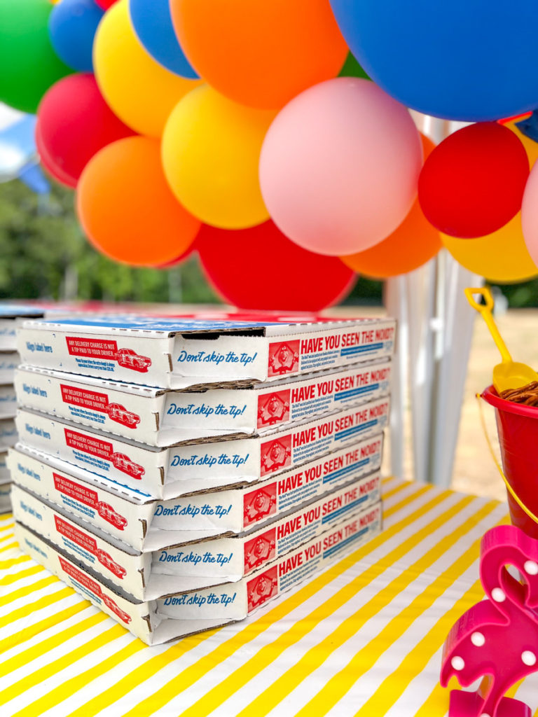 pizza boxes and balloons at a birthday party 