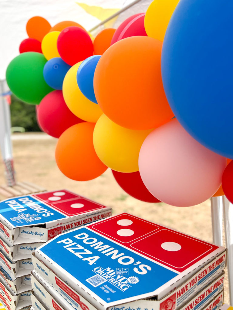 pizza boxes and balloons at a birthday party 