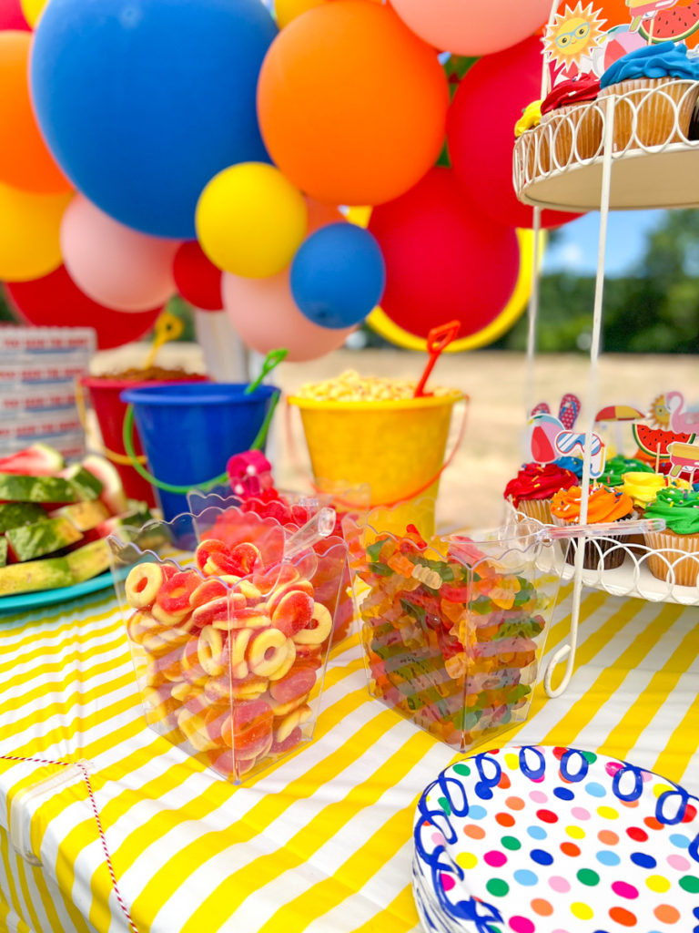 candy displayed on a party table in clear containers 