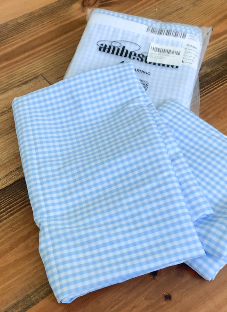 folded up blue and white gingham fabric curtain panels 
