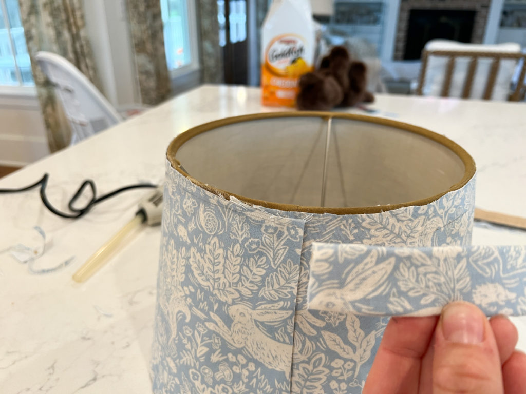 glueing edge banding onto a lampshade covered in fabric 