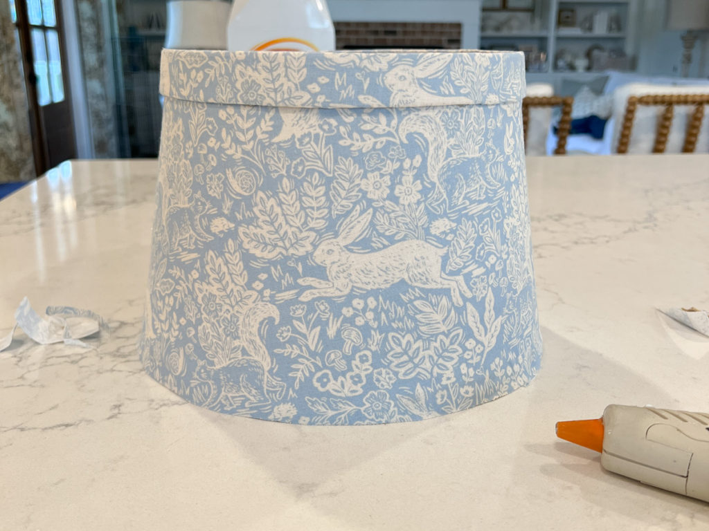 glueing edge banding onto a lampshade covered in fabric 