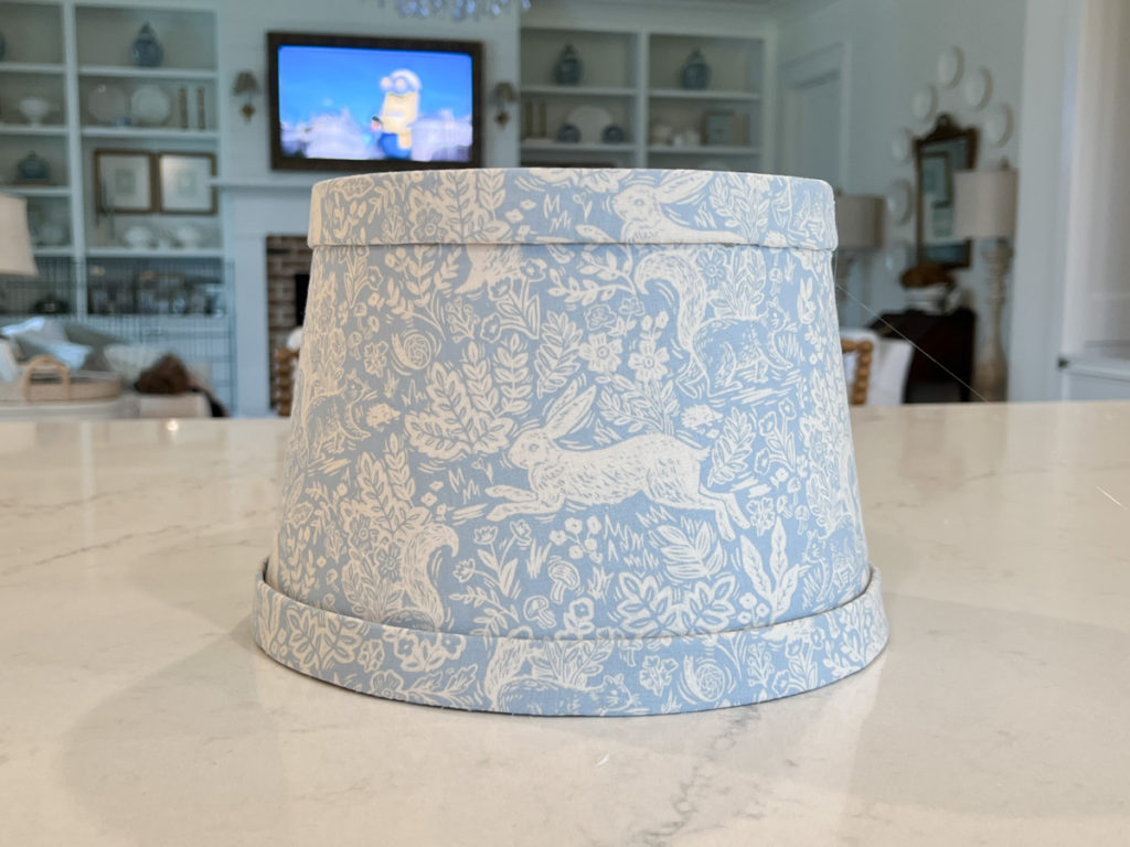 a finished lampshade that has been covered in fabric for a DIY craft project 