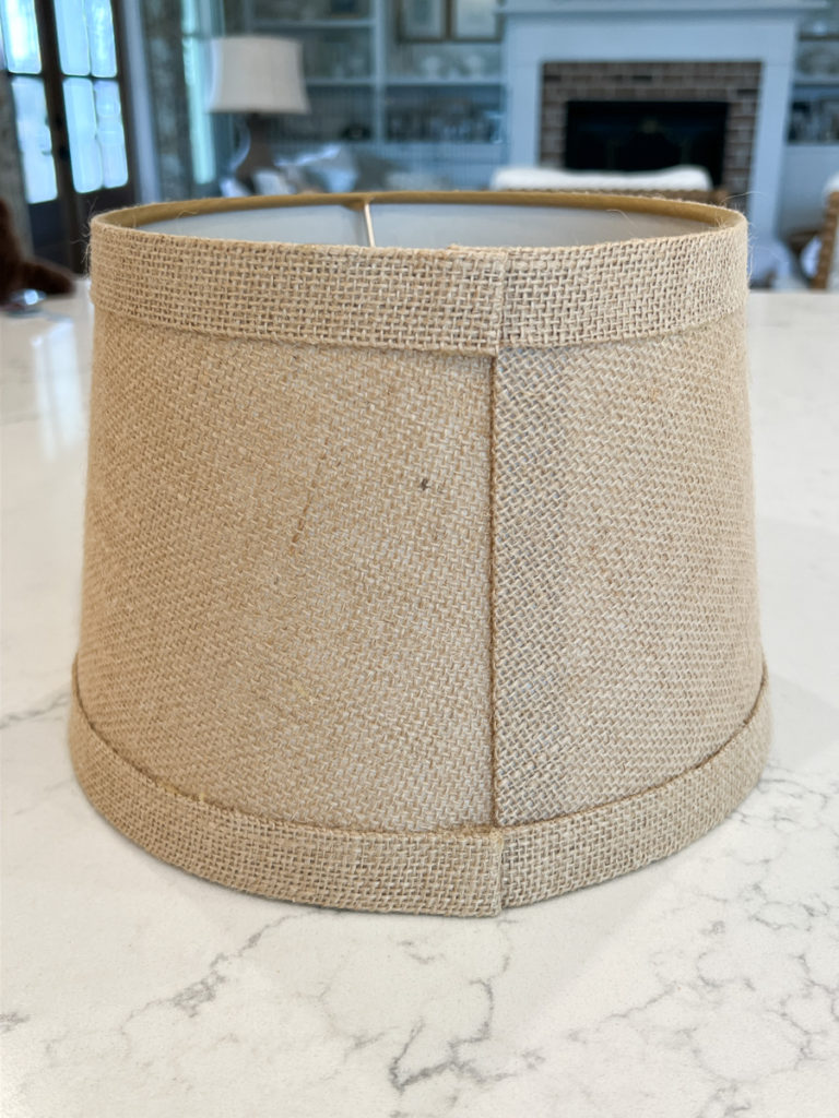 a brown burlap lampshade sitting on a countertop