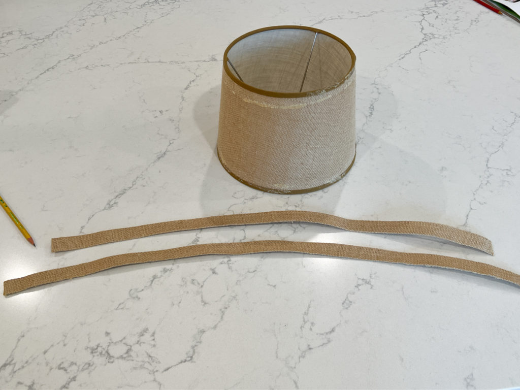 the top and bottom edge banding removed from a burlap lampshade for a DIY project to cover a lampshade with fabric 