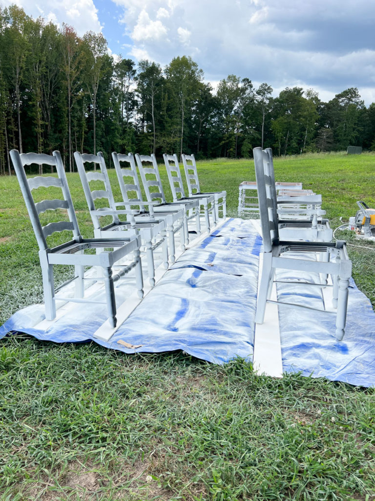 barstools and chairs outside on a tarp ready to be painted