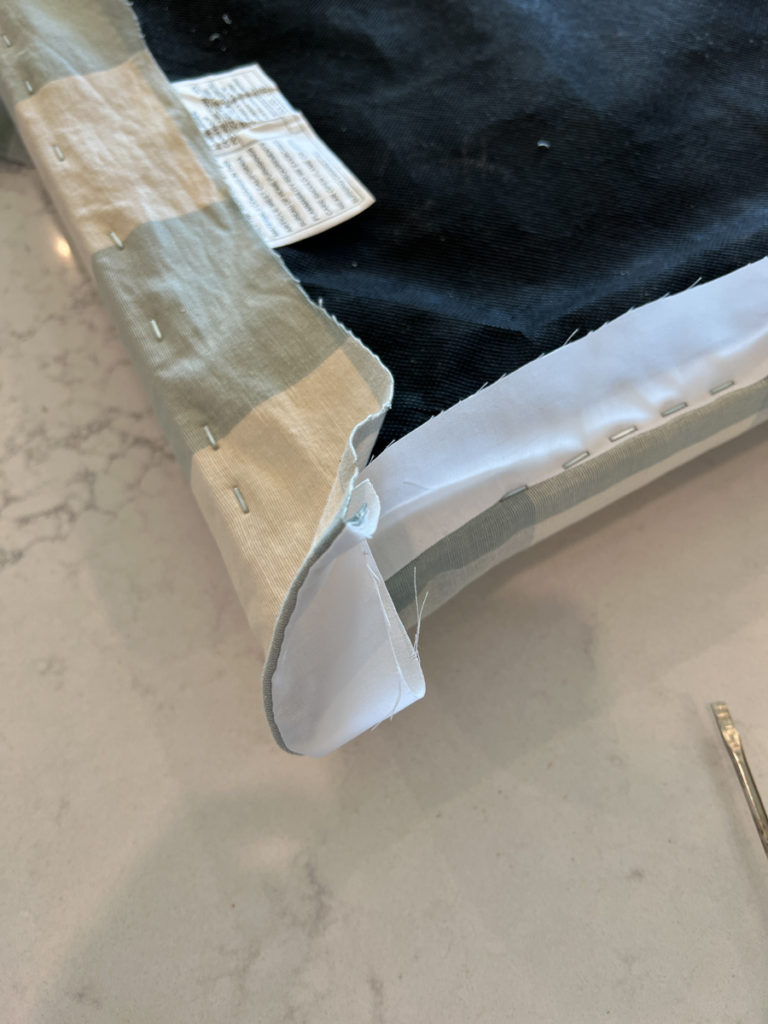 a barstool seat cushion being stapled reupholstered with new fabric 