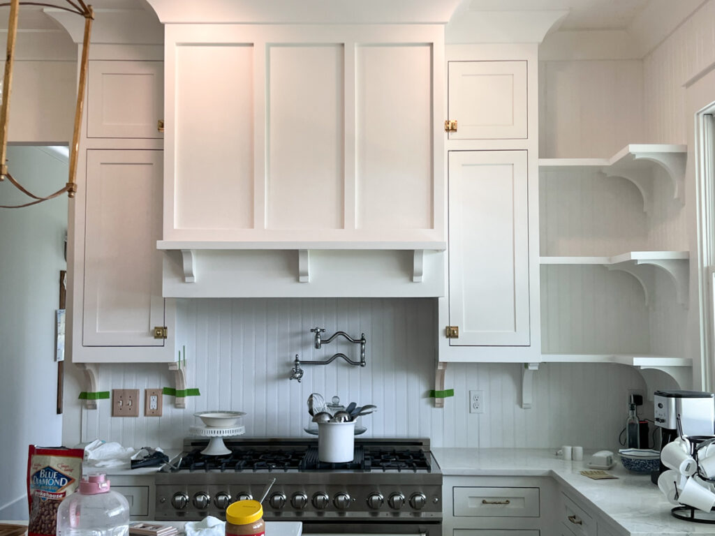 open shelves with corbels in a kitchen painted white 
