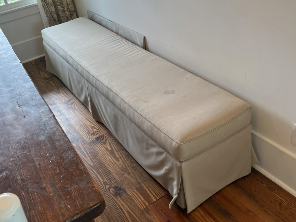 an upholstered bench in tan fabric 