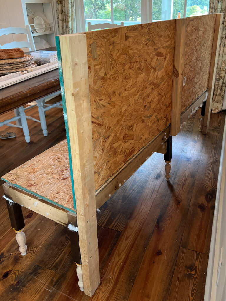 the construction of a DIY banquette bench using 2x4's and plywood to create the frame 