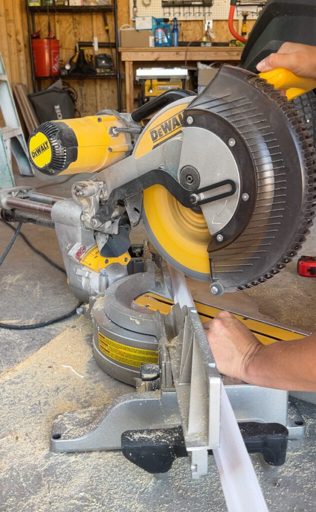 dewalt miter saw cutting a piece of wood trim 