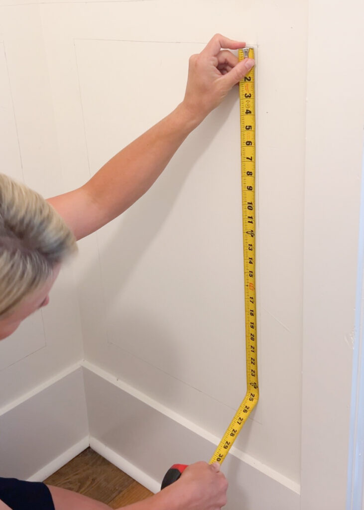 person holding tape measure on a wall 