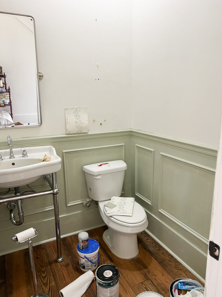 picture frame molding painted sage green in a powder bathroom