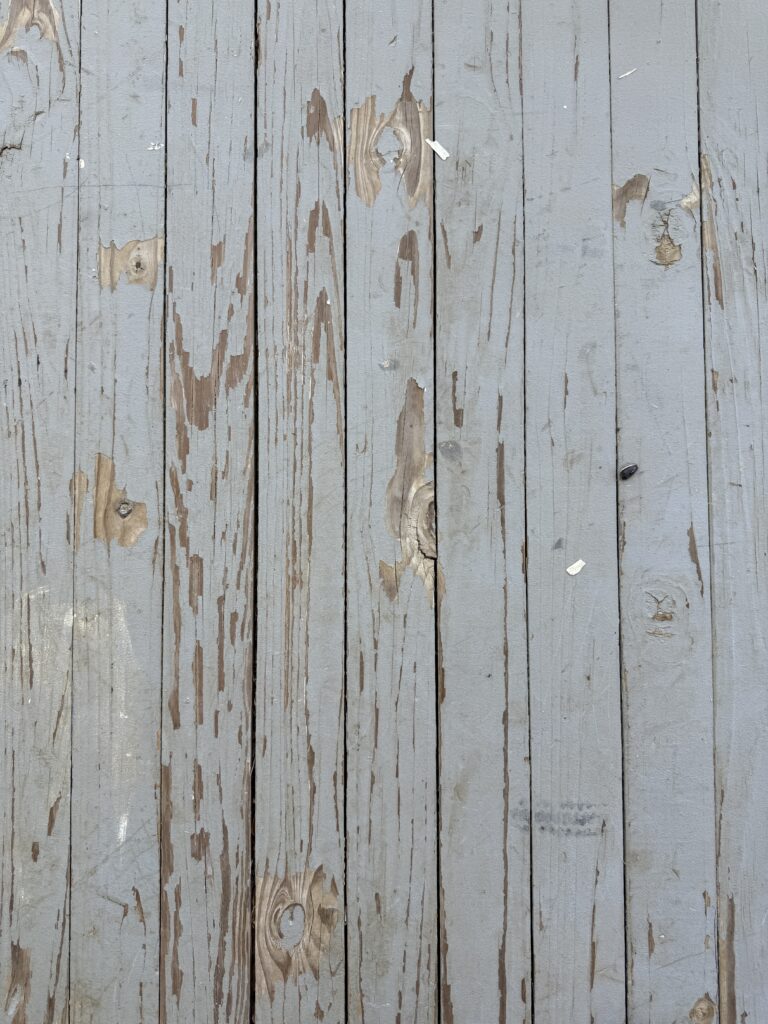 a gray wood porch floor that is peeling, chipping and flaking