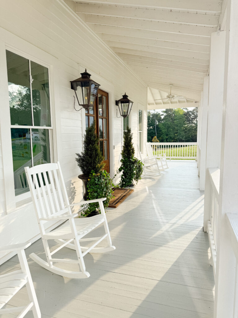 white farmhouse with wrap around porch and gray porch floor