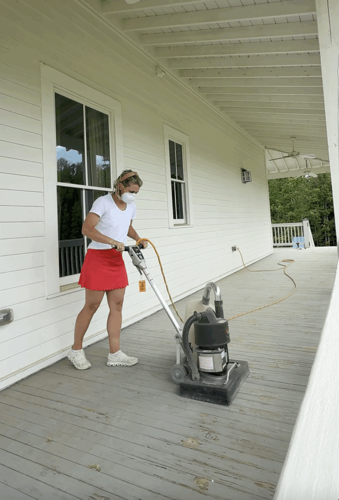 a girl using a floor sander to sand an old porch floor for new paint or stain 